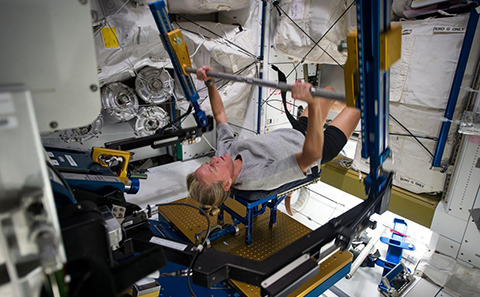 Female astronaut exercising on ISS